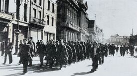 Défilé militaire passant devant l’hôtel de Ville en direction de la rue Pasteur
